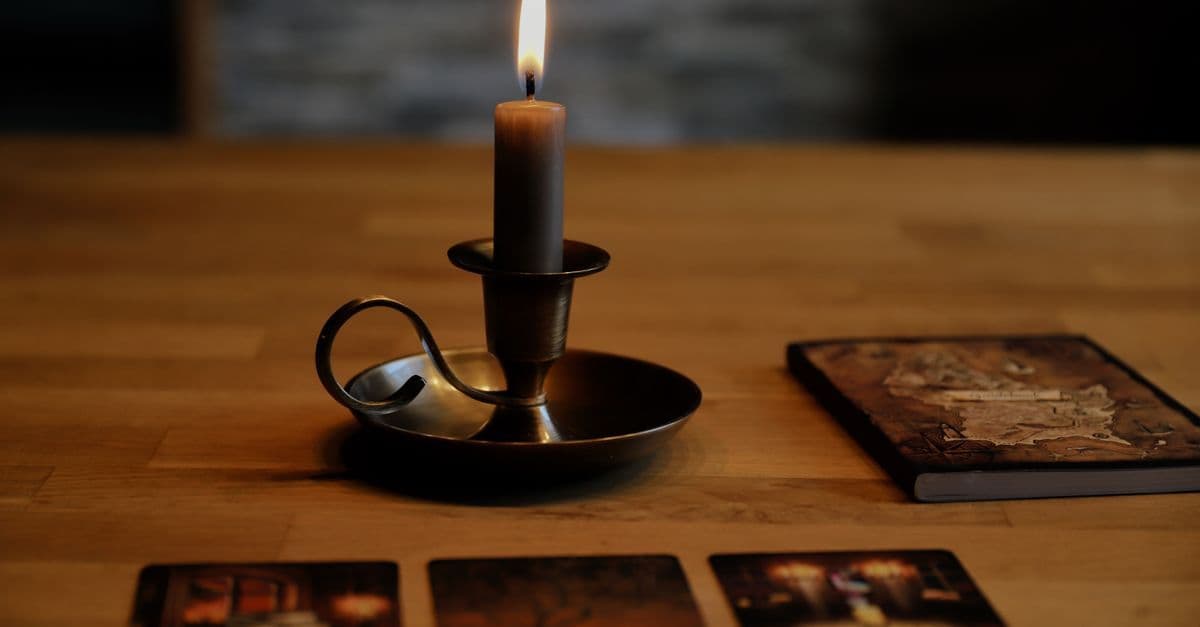 Mistik bir masada mumlar ve tarot kartları