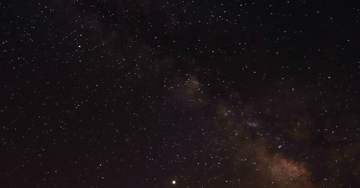 Dağların üzerinde yıldızlarla aydınlanan gece gökyüzü