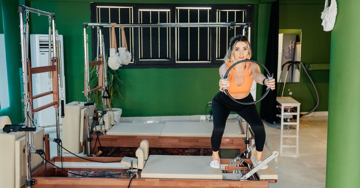 Mat üzerinde pilates yapan ve kontrollü hareket uygulayan kadın