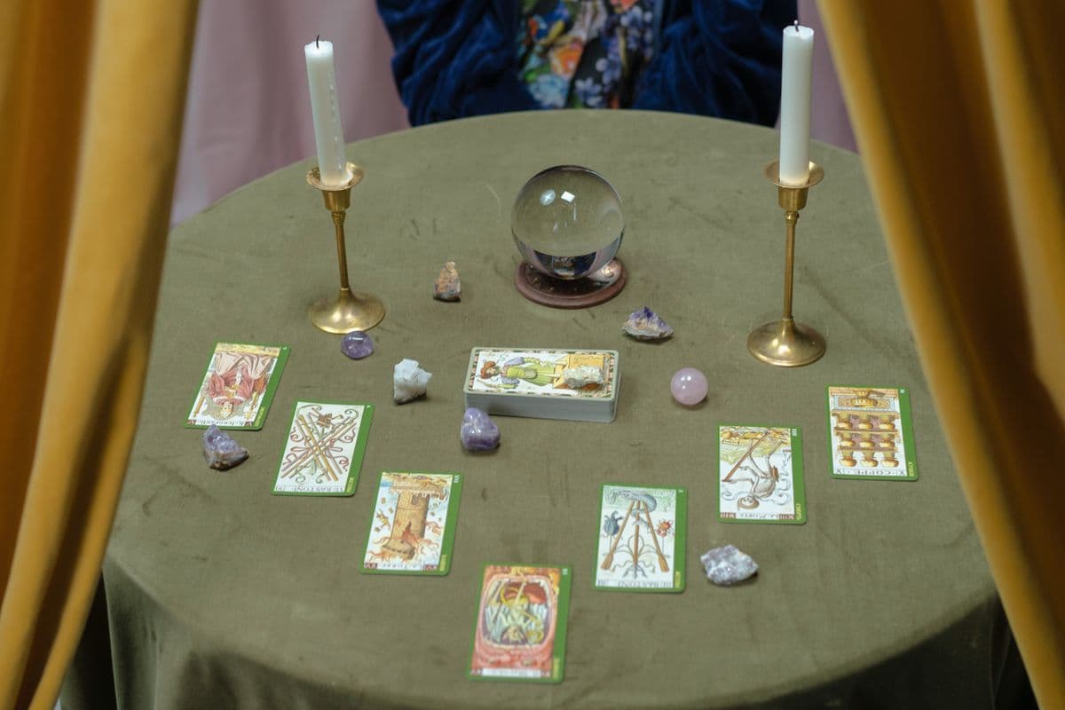 Mumlar ve mistik objelerle çevrili bir masa üzerinde tarot kartları